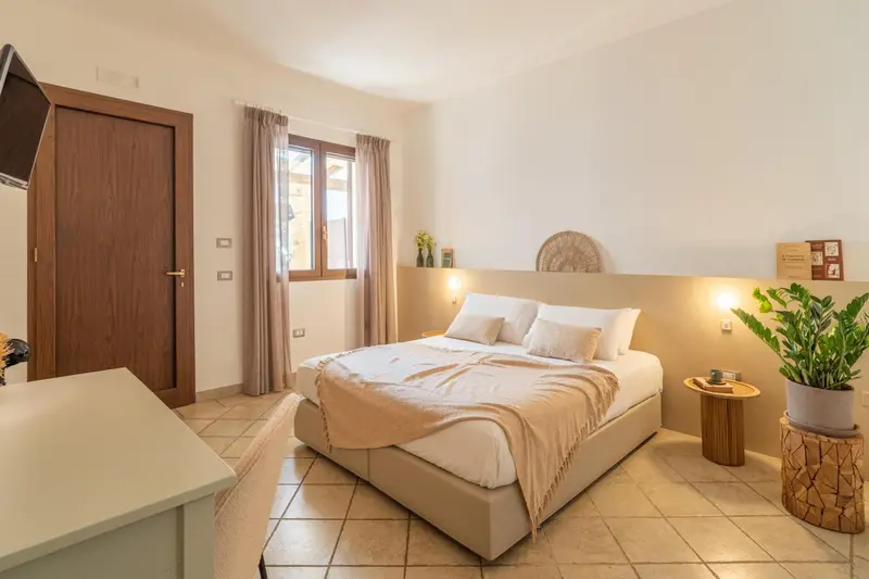 Une chambre lumineuse avec un grand lit et une décoration sobre.