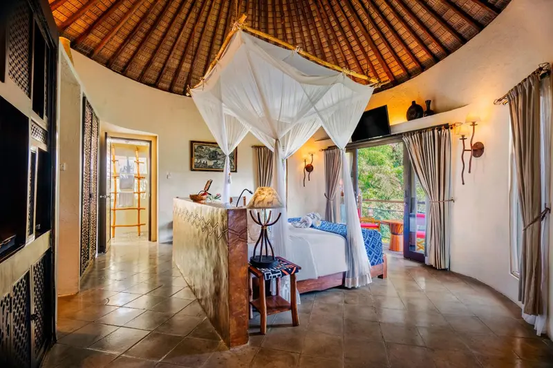 Une chambre lumineuse avec un lit à baldaquin et une baignoire intégrée.