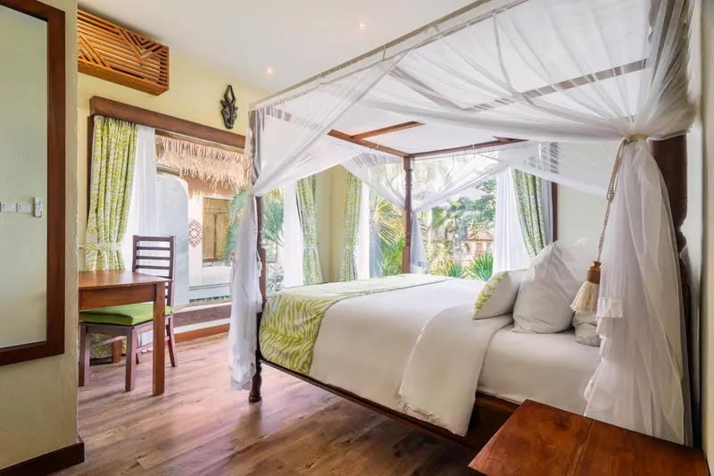 Une chambre avec un lit à baldaquin et un bureau en bois.