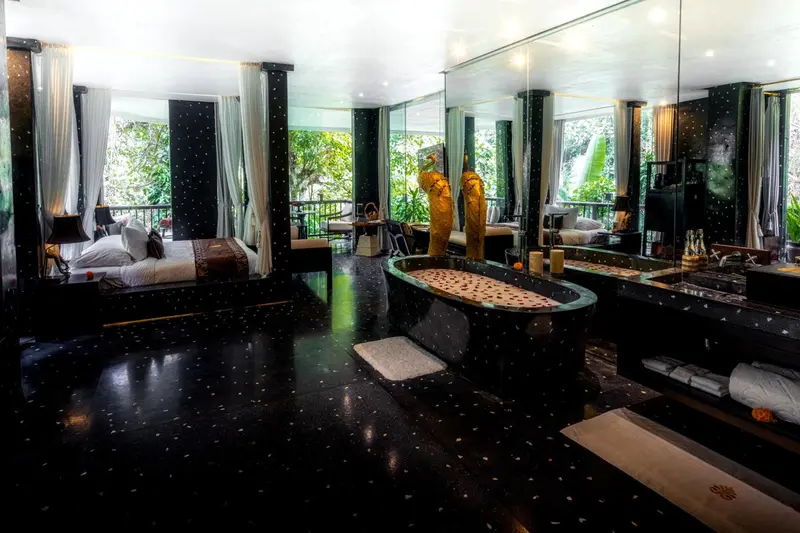 Une chambre spacieuse avec un lit king-size et une baignoire îlot.