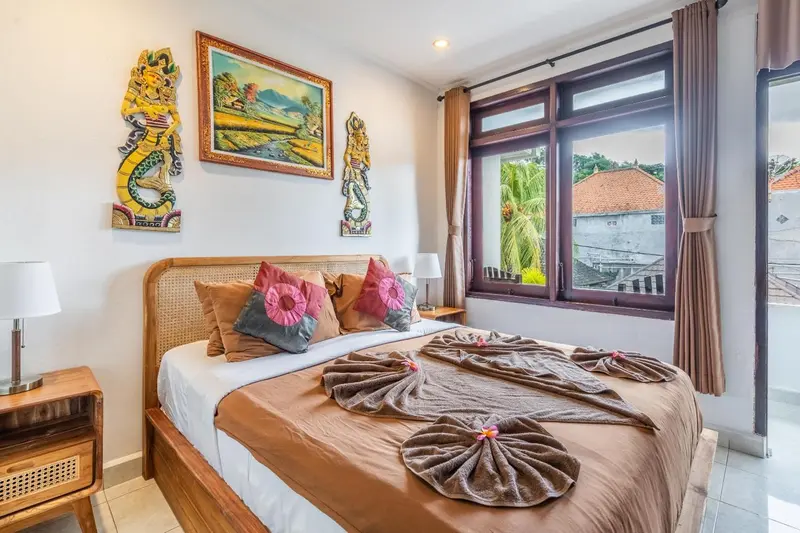 Une chambre lumineuse avec un lit décoré de serviettes en forme de fleurs.