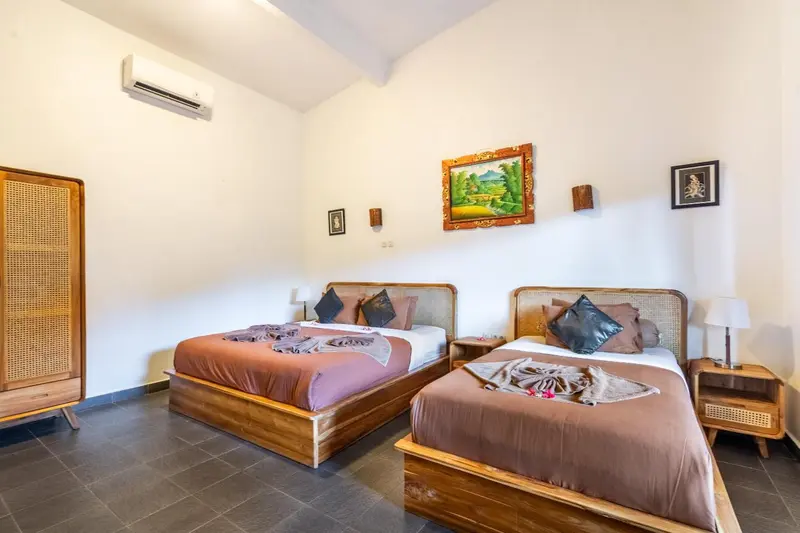 Une chambre lumineuse avec deux lits simples décorés de fleurs.