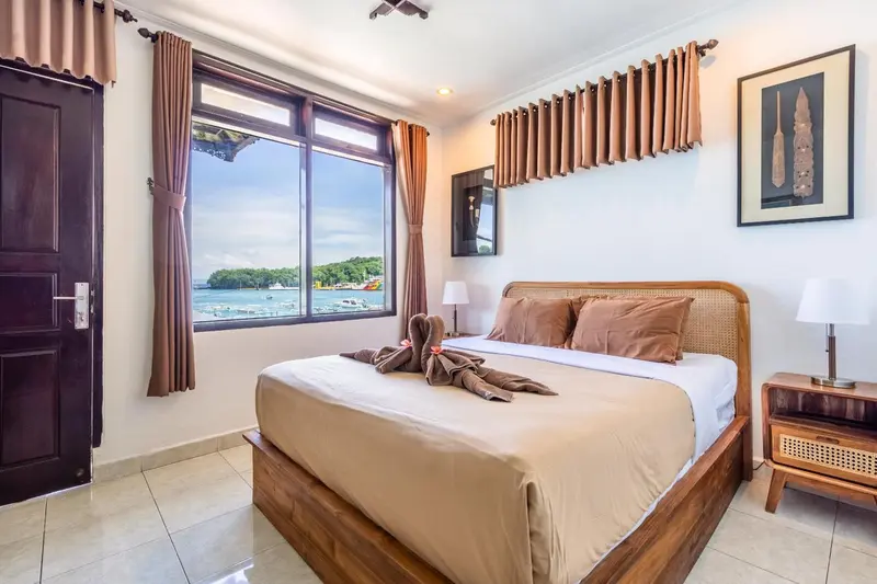 Une chambre lumineuse avec un grand lit et vue sur la mer.
