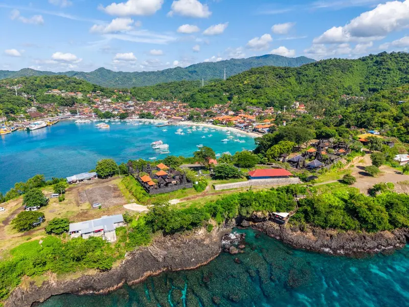 Vue aérienne d'une baie bordée de végétation et de bâtiments.