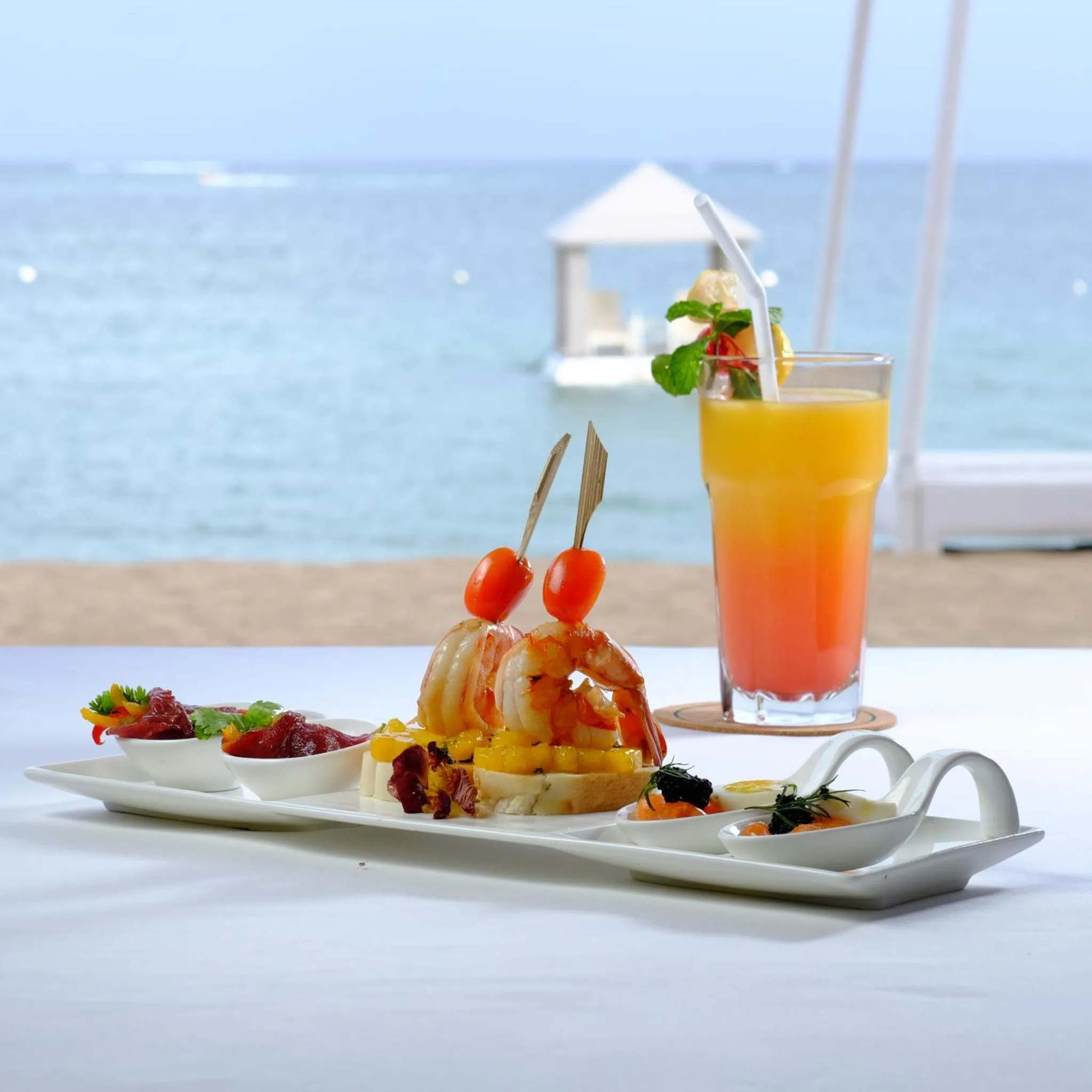 Assiette de fruits de mer et cocktail rafraîchissant sur une table en bord de mer.