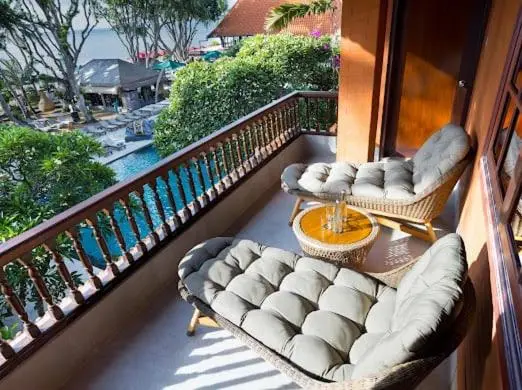 Terrasse aménagée avec des fauteuils confortables et une vue sur la piscine et la mer.