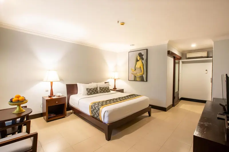 Une chambre d'hôtel lumineuse avec un grand lit et une décoration sobre.