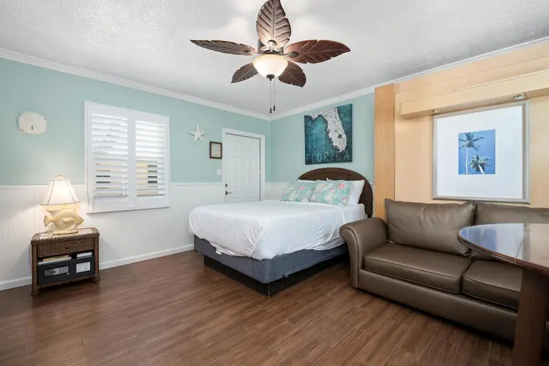 Une chambre lumineuse avec un lit et un coin salon.