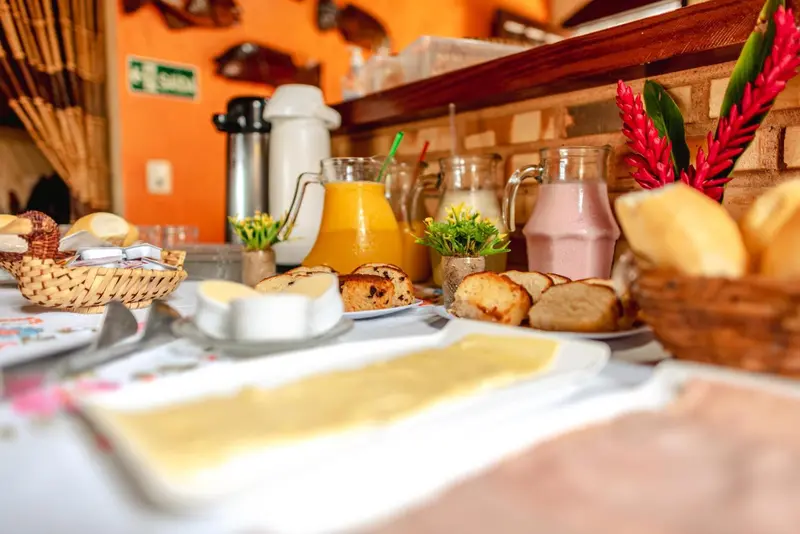 Une table garnie de boissons, de viennoiseries et de confitures.