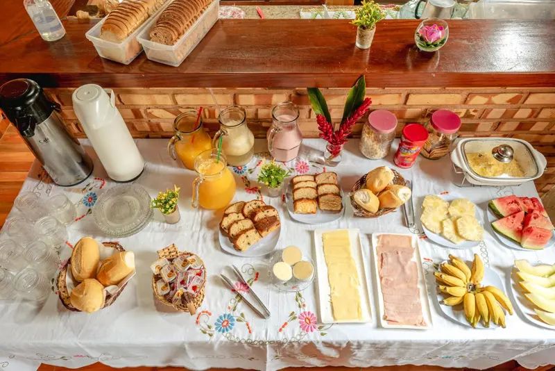 Une table garnie de viennoiseries, de fruits frais et de boissons.