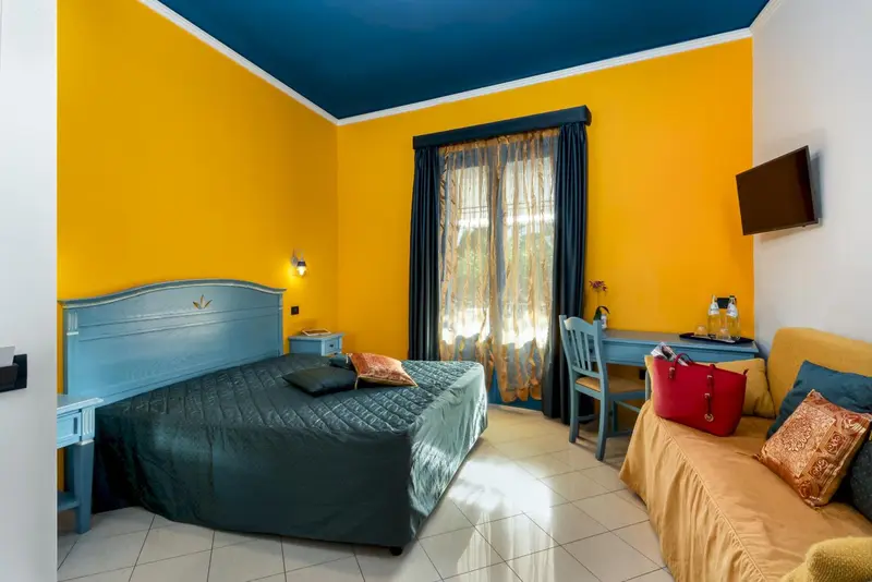 Chambre lumineuse avec un lit double et un coin salon.
