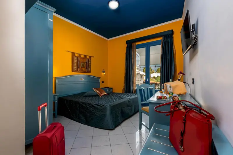 Chambre colorée avec un lit et une fenêtre donnant sur l'extérieur.