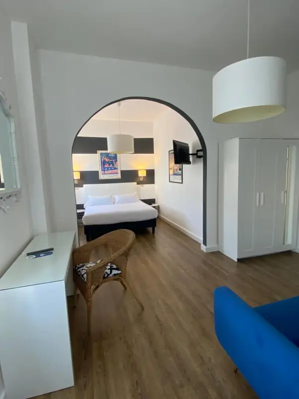 Une chambre lumineuse avec un lit et un espace détente.