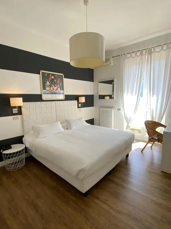 Une chambre lumineuse avec un grand lit et une décoration sobre.