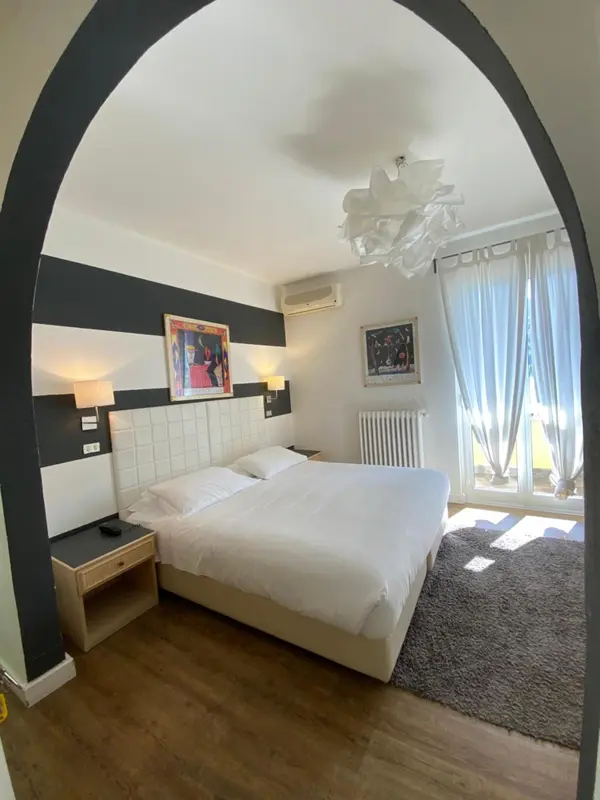 Une chambre lumineuse avec un lit double et une décoration moderne.