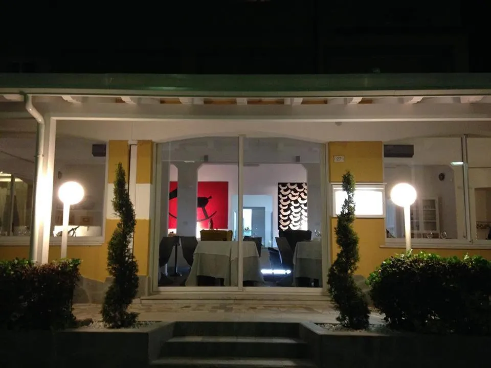 Entree d'un restaurant avec des tables dressées et un éclairage chaleureux.