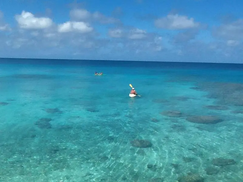 Vue aérienne d'une eau turquoise et claire avec des kayaks.