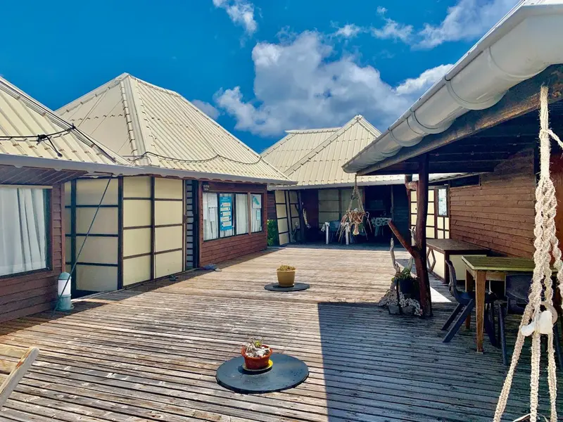 Terrasse en bois avec des bâtiments aux toits inclinés sous un ciel nuageux.