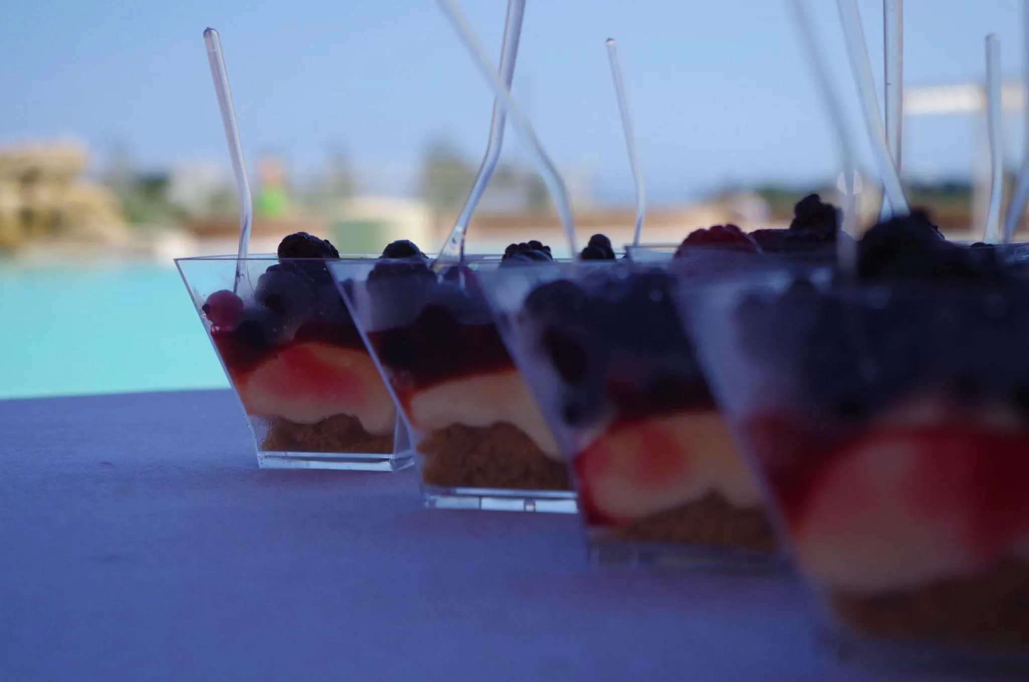 Assortiment de verrines aux fruits frais disposées en rangée sur une table.