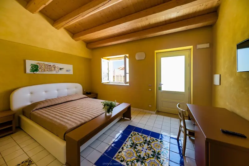 Une chambre lumineuse avec un grand lit et un carrelage décoratif.