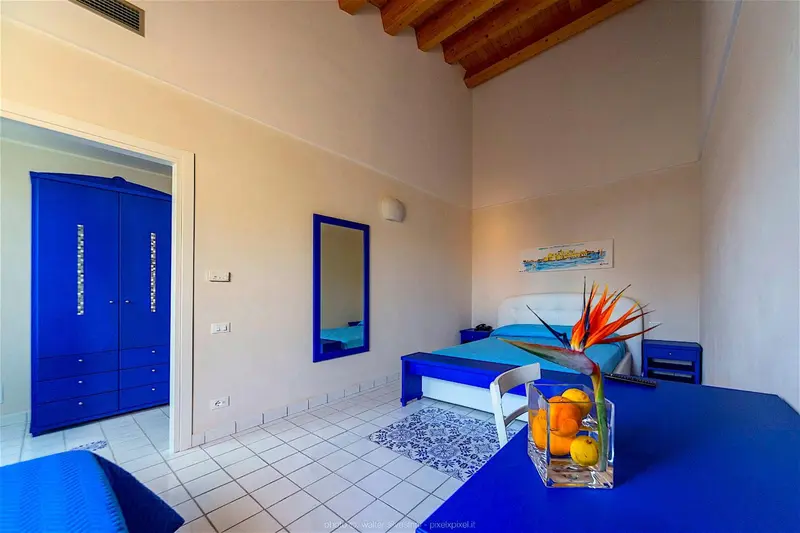 Une chambre lumineuse avec un lit et un grand placard bleu.