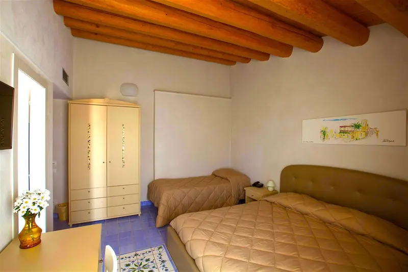 Une chambre lumineuse avec deux lits simples et un bureau.