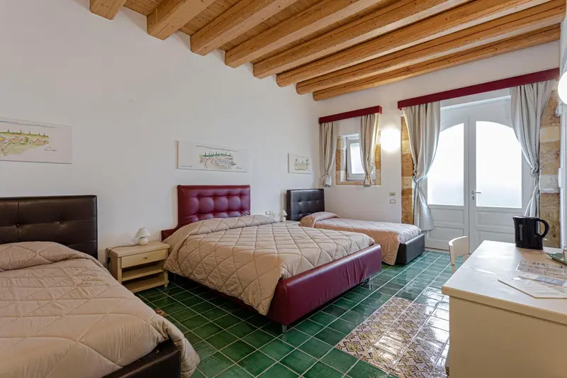 Chambre avec deux lits et une fenêtre donnant sur l'extérieur.