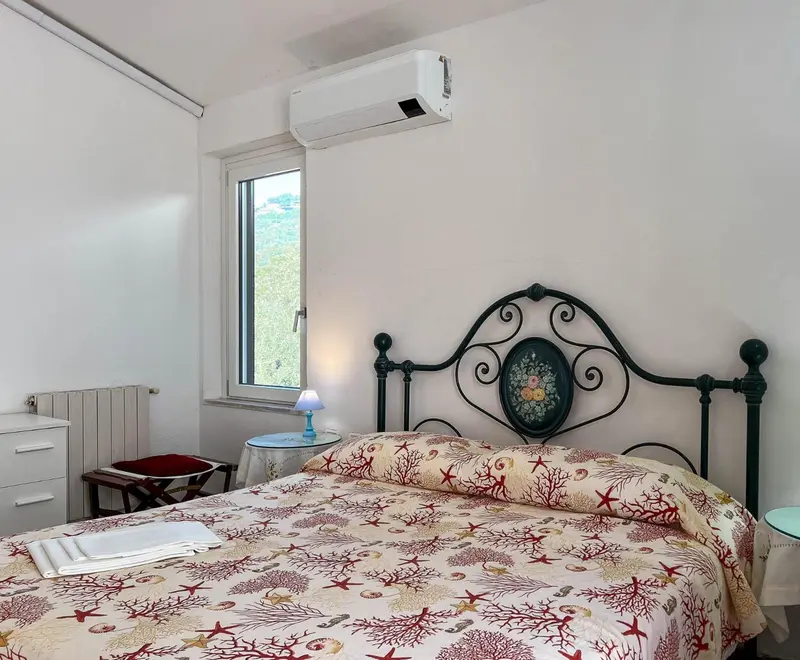 Une chambre lumineuse avec un lit recouvert d'une courtepointe décorative.
