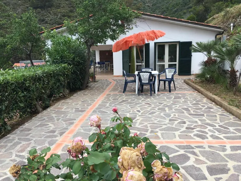 Terrasse pavée avec mobilier de jardin devant un bâtiment.