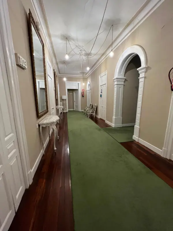 Un long couloir d'hôtel avec des portes de chambres de chaque côté.