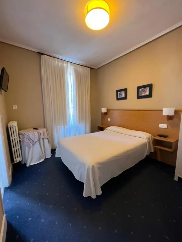 Une chambre d'hôtel avec un lit et des rideaux.
