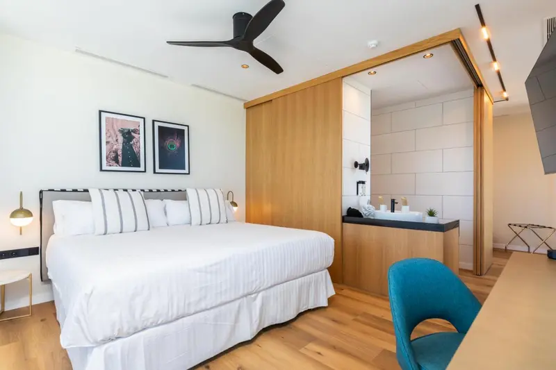 Une chambre lumineuse avec un grand lit et un espace détente.