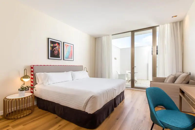 Une chambre lumineuse avec un grand lit et un espace détente.