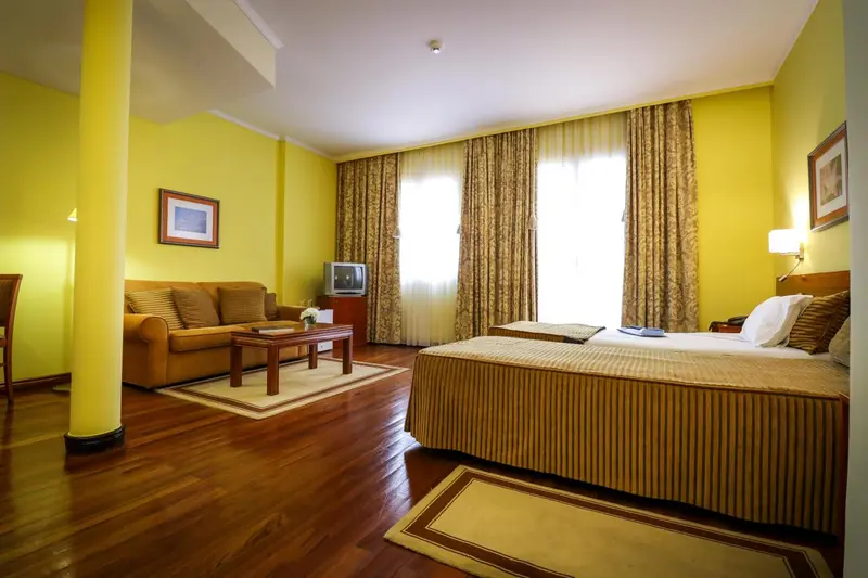 Une chambre lumineuse avec un canapé et un lit.