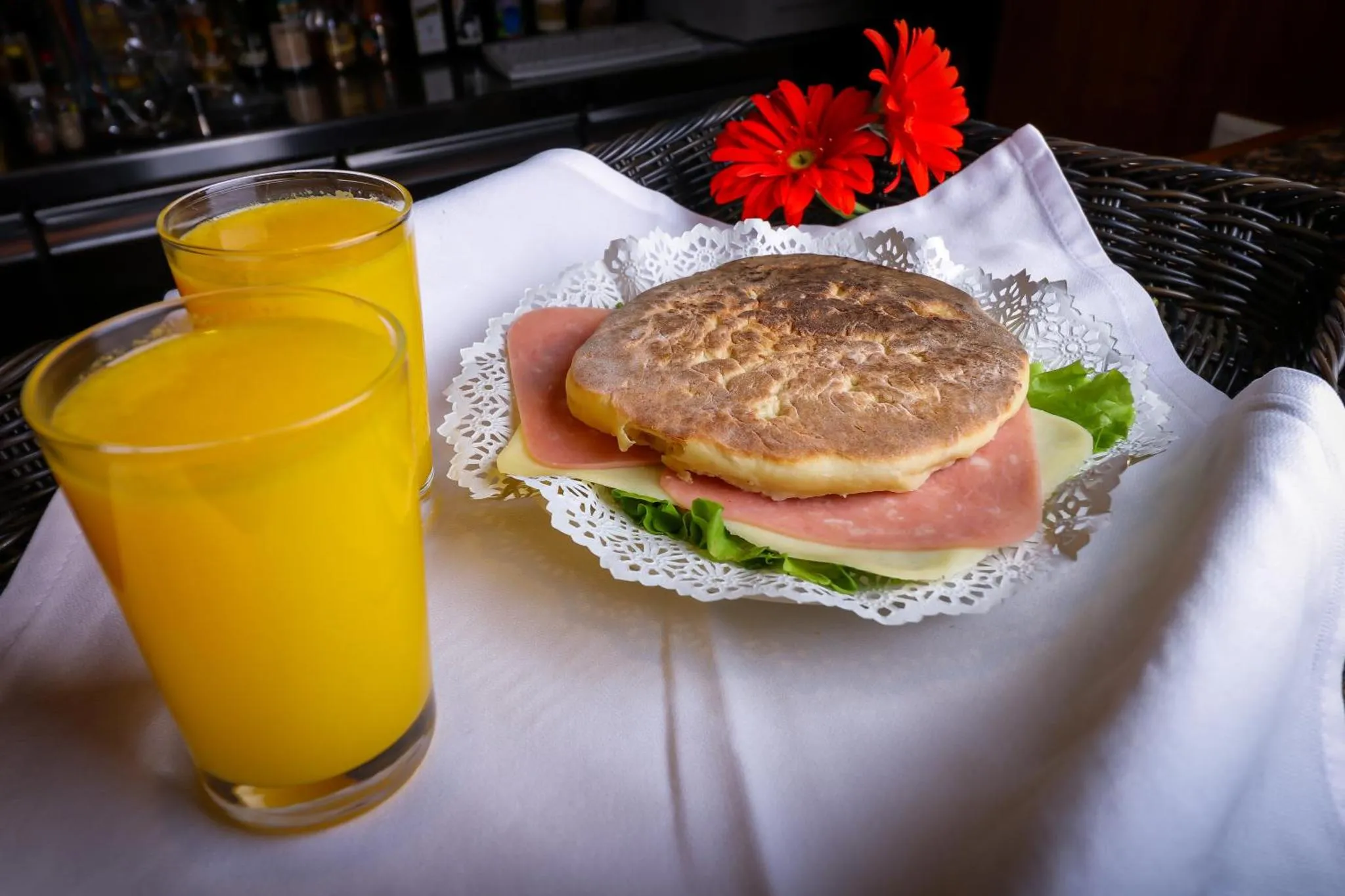 Un sandwich et un jus d'orange sont servis sur une table.