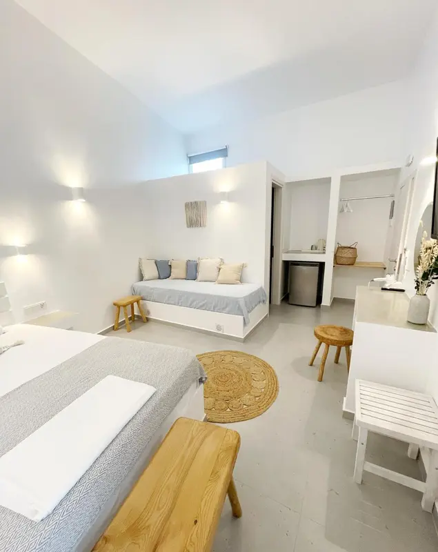 Une chambre lumineuse avec un lit et un espace détente.