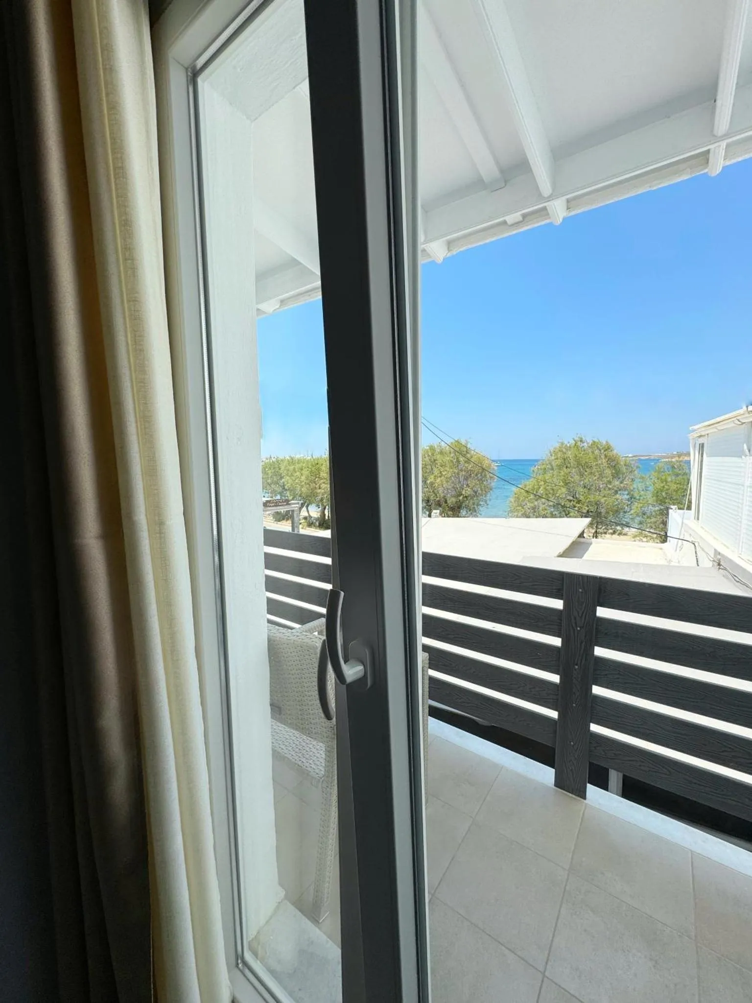 Vue sur la mer depuis une terrasse ensoleillée.