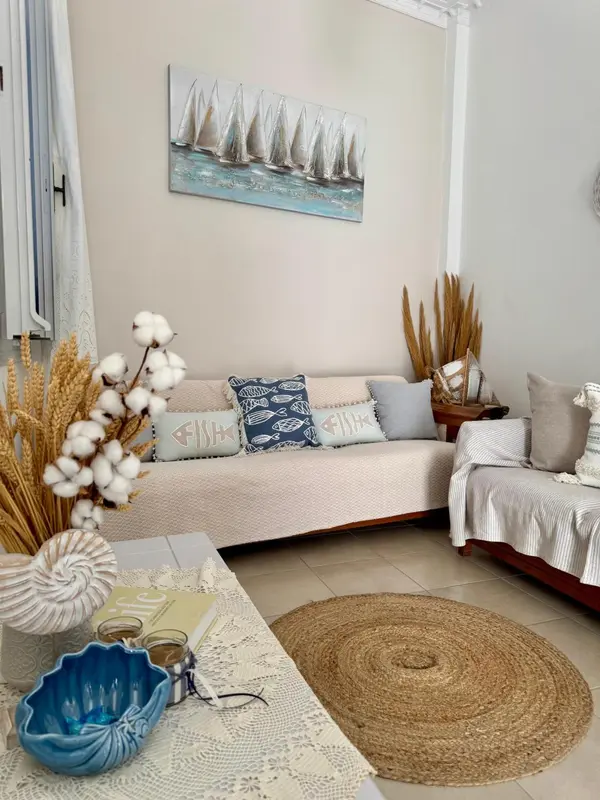 Un canapé beige et des coussins décoratifs ornent un espace de détente intérieur.