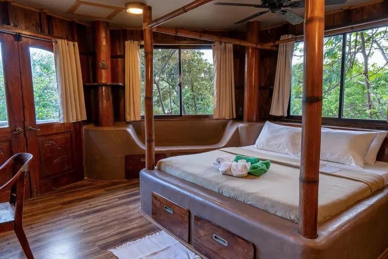 Une chambre avec un grand lit à baldaquin en bois et une décoration naturelle.