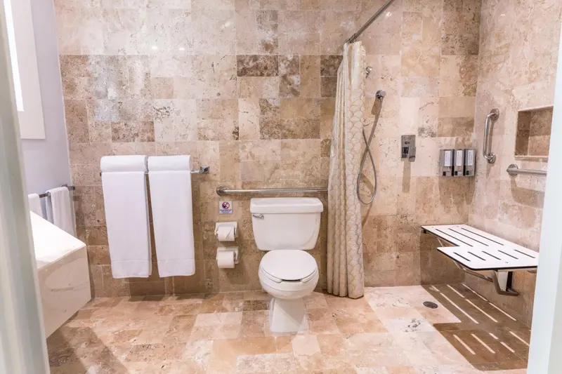 Une salle de bain carree avec douche a l'italienne et parois en verre.