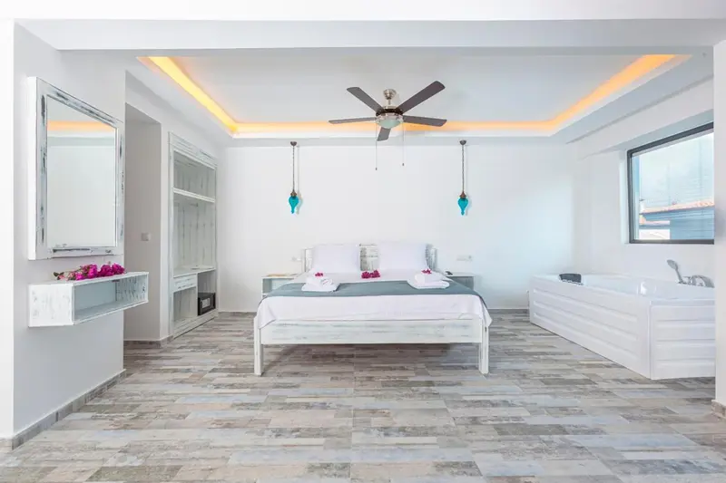 Une chambre lumineuse avec un lit double et une baignoire.