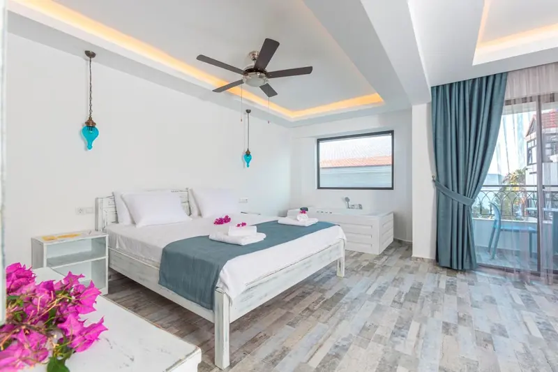 Une chambre lumineuse avec un grand lit et un accès à un balcon.
