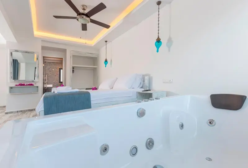Une chambre lumineuse avec un lit double et un jacuzzi.