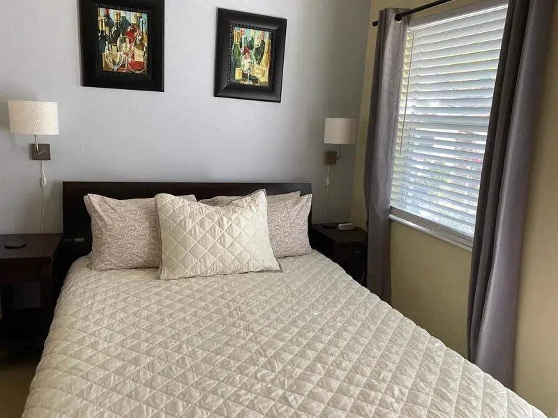 Une chambre lumineuse avec un grand lit recouvert d'une courtepointe.