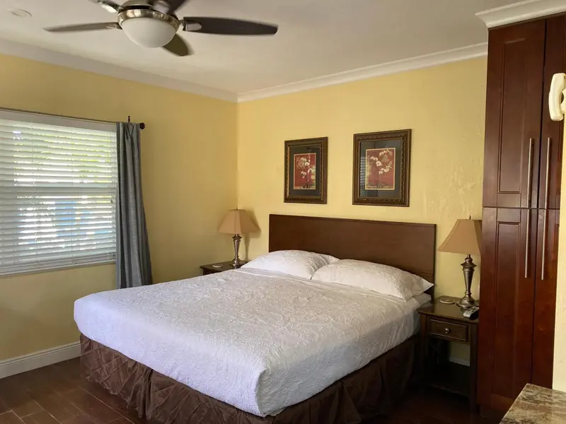 Une chambre lumineuse avec un grand lit et des tableaux décoratifs.