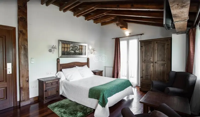 Une chambre à coucher avec un lit à baldaquin et un coin lecture.