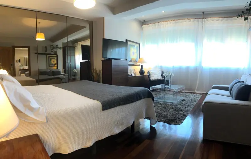 Une chambre spacieuse avec un grand lit et un coin salon.