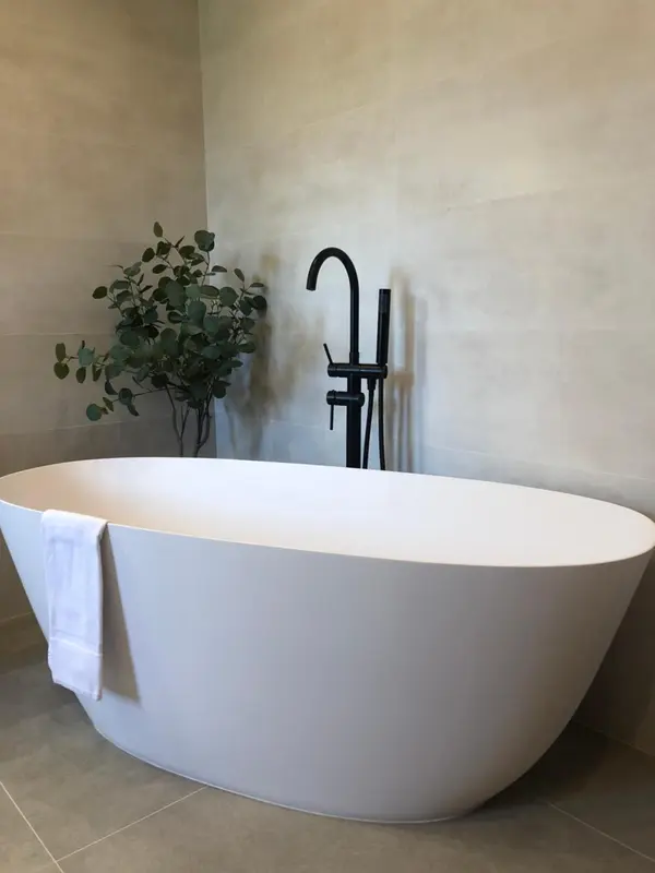 Une baignoire blanche moderne est mise en valeur dans une salle de bain minimaliste.