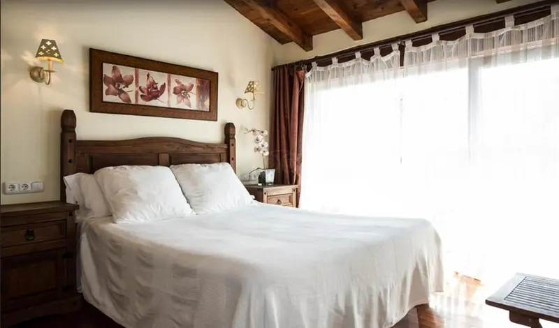 Une chambre lumineuse avec un grand lit recouvert de draps blancs.