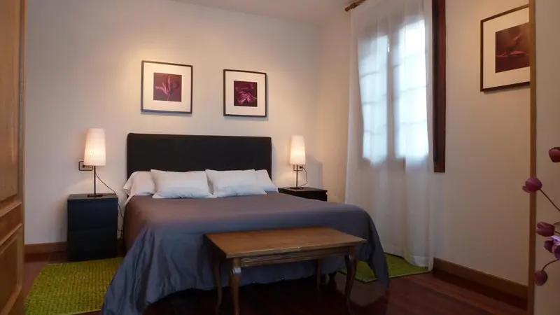 Une chambre à coucher avec un grand lit et deux tableaux au mur.